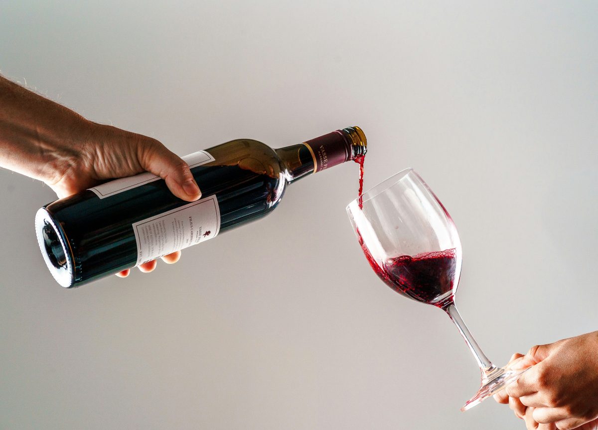 une personne versant un verre de vin dans la main d’une autre personne